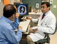 Jerry Krishnan discusses findings of a lung x-ray with a patient.